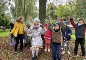 dzieci bawią się wśród jesiennych liści
